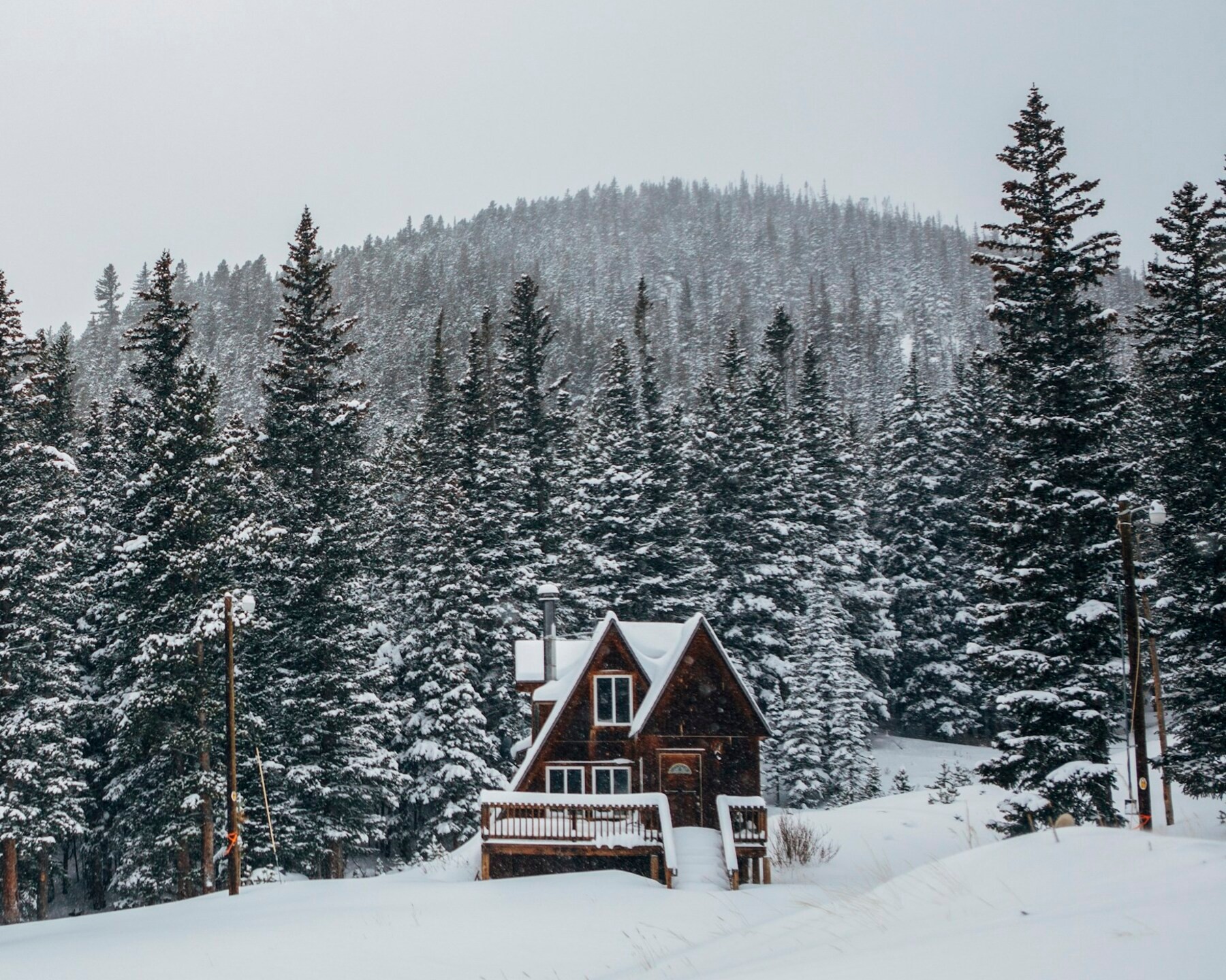 Mountain cabin in deep snow below a forested ridge, Eagle Point Utah wildfire recovery solar and battery